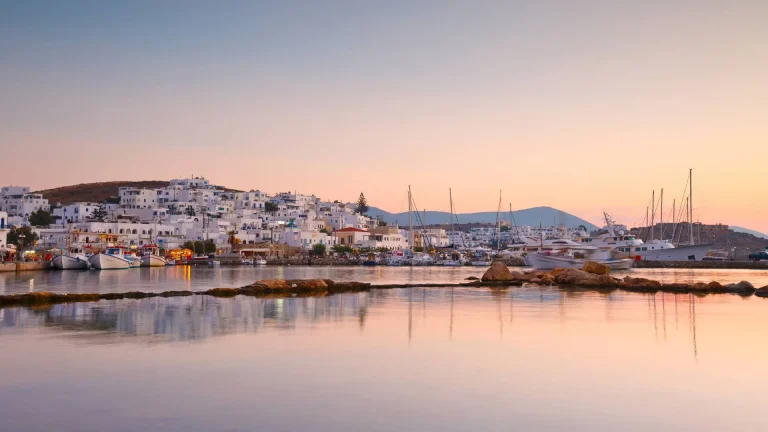 A view of the small village Naousa in Paros during sunset. A lot of white houses and boats.