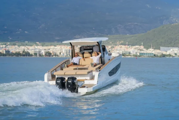 Two people sitting on the back of a speed boat.